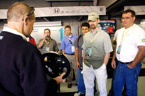 Steve Wolf demonstrates the new paddle shifting features on the IndyCar steering wheel to EPIC members at the Team Ethanol garage the day before the 2008 Indy 500