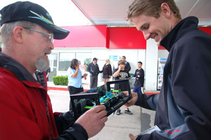 Ryan Hunter-Reay autographs a replica of the Team Ethanol No. 7 IndyCar for a race fan